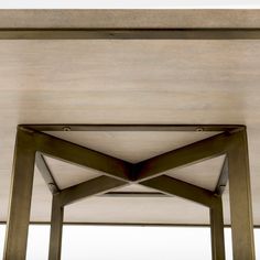 the underside of a wooden table with metal legs and an open roof area in front of it