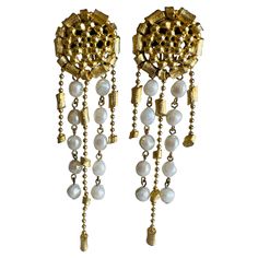 These vintage earrings make a powerful statement with their hefty weight and well-constructed design, perfect for high-end fashion and runway styles. The dramatic length adds a bold, eye-catching effect, while the textured gold-tone discs are lavishly adorned with dangling imitation pearls. This look captures haute couture glamour, offering an opulent touch to any ensemble. Size: Approximately 4-3/4" x 1-1/4" wide. Weight: 48 grams. Markings: Unsigned. Condition: Excellent vintage condition with little to no wear. Well-constructed earrings with tight working clip backs. Pearl Gold Earrings, Haute Couture Runway, Long Crystal Earrings, Earring Video, Shoulder Duster Earrings, Gold Pearl Earrings, Couture Runway, Amethyst Quartz, Stunning Earrings