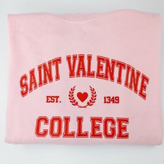 This Saint Valentine's College sweatshirt is the perfect twist on your typical collegiate sweatshirt. The graphic features an athletic font with a heart crest in the center. This sweatshirt is perfect for lounging around the house, running errands, or gifting to your favorite Galentine. Unisex Sizing; Size up for an oversized fit Pill-resistant fleece Machine washable 50/50 cotton/poly blend Screen Printed in Red Ink Sweatshirt color is Light Pink Winter College T-shirt With Logo Print, Collegiate Hoodie With Logo Print And Crew Neck, Collegiate Crew Neck Hoodie With Logo Print, Varsity Letter Print Sweatshirt For College, College Logo Print Crew Neck Sweatshirt, Sporty College Hoodie With Lettering, Pink Varsity Sweatshirt For College, School Spirit Long Sleeve Sweatshirt With Logo, Collegiate Sweatshirt With University Logo