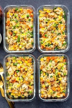 four glass containers filled with rice and vegetables on top of a table next to silverware