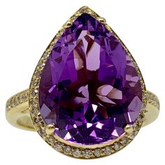 This big and dramatic Amethyst and white diamond ring features a large Amethyst weighing 5 carat in the center with halo of small white diamonds weighing 0.50 carat with VS clarity and GH color. This piece is created by hand in 14k yellow gold and has a spectacular look. The ring size is 7 and can be resized. Formal Amethyst Ring With Diamond Accents, Luxury Purple Diamond Ring With Halo Setting, Luxury Amethyst Ring With Diamond Halo Setting, Formal Amethyst Ring With Halo Setting And Cubic Zirconia, Formal Amethyst Ring With Halo Setting, Fine Jewelry Diamond Amethyst Ring With Halo Setting, Formal Purple Diamond Ring With Halo Setting, Purple Brilliant Cut Diamond Ring, Yellow Gold Amethyst Diamond Ring With Halo Setting