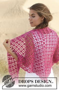 a woman wearing a pink crochet shawl in front of a desert landscape