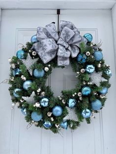 a christmas wreath with blue and silver ornaments