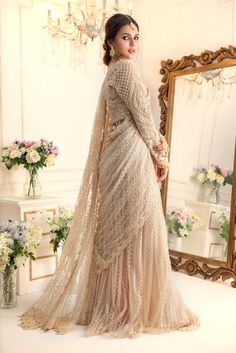 Taking inspiration from Ornamental art, this stunning Lehenga saree features monotonal threadwork further enhanced with pearls, sequins, crystals, beads and Swarovski stones. This look is completed with embroidered pleated flowy lehenga & embellished embroidered net stylized dupatta which can be hooked and worn as per your comfort creating gorgeous saree silhouette making it an ideal choice for any celebratory occasion. Fabric: Embroidered NetColor: Beige This is a made to measure look, once ord Elegant Designer Pre-draped Saree With Resham Embroidery, Elegant Festive Pre-draped Saree With Intricate Embroidery, Floor-length Saree With Sheer Dupatta For Reception, Elegant Designer Lehenga With Pearl Embroidery, Designer Pearl Embroidery Lehenga, Elegant Organza Lehenga With Pearl Embroidery, Designer Pearl Embroidered Elegant Lehenga, Elegant Semi-stitched Lehenga With Pearl Embroidery, Festive Pre-draped Saree With Pearl Embroidery