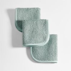 three light blue towels on a white surface