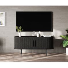 an entertainment center with a flat screen tv mounted on the wall and plants in vases next to it