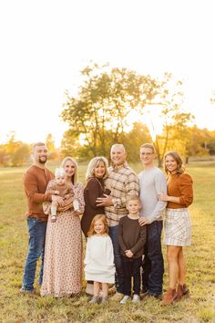 a family posing for a photo in an open field at sunset with the sun behind them