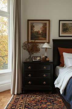 a bedroom with a bed, dresser and painting on the wall next to a window