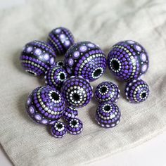 purple beads are sitting on a white cloth