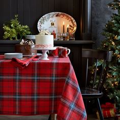 a table topped with a cake next to a christmas tree