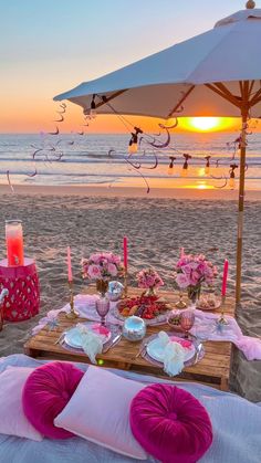 a table set up on the beach at sunset