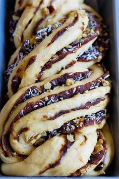 some kind of bread with nuts and chocolate on top in a blue box, ready to be eaten