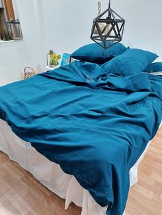 a bed with blue sheets and pillows in a room