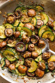 a pan filled with cooked zucchini and mushrooms