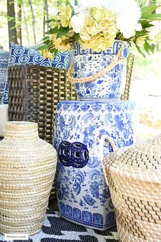 blue and white vases sitting on top of a table next to wicker baskets