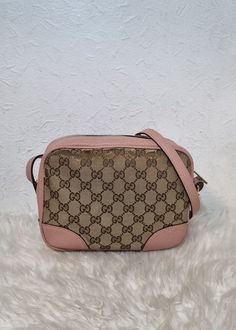 Gucci GG Monogram Bree crossbody bag. Features a GG monogram and pink leather exterior and adjustable crossbody strap. Fabric lined interior with multiple compartments. Top zip closure, and side GG charm. Please view pictures and read descriptions to know the condition of the bag.  Exterior has some canvas wear around the edges. Scuffs around leather piping and bottom edges. Interior is discoloured and abrasions on strap. Fading on zipper head/ hardware. Cute piece. No damage and no added accessories. W - 8.7 x H - 6.7 x D - 2.8 inches Gg Monogram, Sling Bags, View Pictures, D 2, Pink Leather, Crossbody Strap, Cross Body Handbags, Purses And Handbags, Crossbody Bags