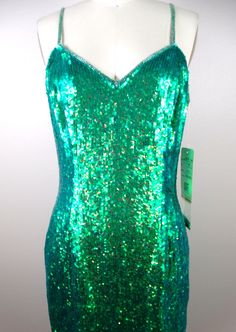 "The color of this one is ELECTRIC! It's fully embellished with iridescent mermaid green sequins all over! It's in perfect condition with the original retail tags still attached and also comes with a small bag of matching embellishments. ABSOLUTELY AMAZING! Bust - 36\" Waist - 28\" Hips - 38\" Length - 35\" Tag Size - 6 This dress comes from a pet-free and smoke-free home. If you would like more info or have any questions, please don't hesitate to ask!" Green Sleeveless Mermaid Dress For Prom, Glamorous Green Sequin Dress For Homecoming, Glamorous Green Sequin Homecoming Dress, Green Mermaid Dress For Party Season, Green Mermaid Evening Dress For Prom, Elegant Green Sequin Homecoming Dress, Fitted Mermaid Dress With Contrast Sequin For Prom Season, Fitted Green Mermaid Dress For Night Out, Green Mermaid Dress For Prom Season