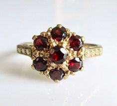 This is a vintage 9ct yellow gold cluster ring featuring six round red (0.05ct each) garnets surrounding a single round (0.07ct) garnet forming a colourful hexagonal cluster. Weighs 2.4 grams Cluster measures 10mm x 10mm UK size K, USA size 5 1/8 Fully Hallmarked 375 (9ct Gold) made in London in the year 1967. Flower Cluster Ring, Cluster Ring Set, Vintage Jewelry Antique, Edwardian Jewelry, Flower Cluster, Pretty Rings, Multi Stone Ring, Ruby Ring, Red Garnet