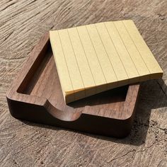 two pieces of wood sitting on top of a wooden tray with one piece cut out