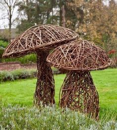 two sculptures made out of sticks in the grass