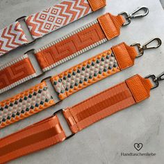 three orange and white belts with matching buckles