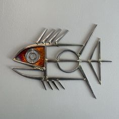 a fish made out of metal with scissors on it's side and eyes in the center