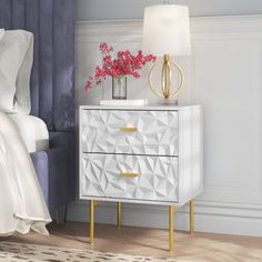 a bedroom with a bed, nightstand and flowers on the night stand in front of it