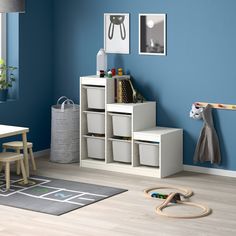 a child's playroom with blue walls and wooden furniture, including toys on the floor