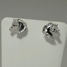 Silver Horse head earrings with sapphire eyes. Opposite facing, for pierced ears these are part of my signature range, that match the Horse head Bangle, and Horse head ring - all set with sapphires in the eyes. All silver items are Sterling Silver, Hallmarked by The London Assay Office. All orders containing silver items come with a free polishing cloth, to keep your silver shiny and bright. Clip-on White Gold Sterling Silver Jewelry, Clip-on Sterling Silver Jewelry In White Gold, Sterling Silver Clip-on Jewelry In White Gold, Adjustable Clip-on Sterling Silver Jewelry, Silver Clip-on Earrings Fine Jewelry, Collectible Silver Jewelry With Matching Earrings, Unique Silver Clip-on Jewelry, Sapphire Eyes, Silver Horse