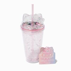 a hello kitty cup next to a small pink soap bar on a white background with the lid open