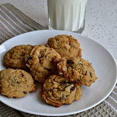 a white plate topped with cookies next to a glass of milk