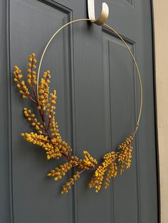 a wreath with yellow flowers hanging on the front door