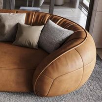 a large round couch with many pillows on it