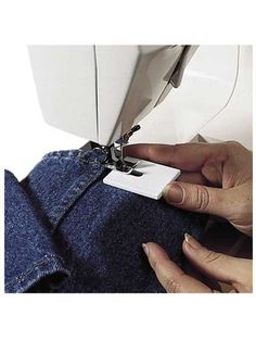 someone using a sewing machine to sew jeans