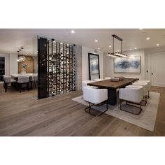 a dining room table with white chairs and a wine rack in the backround