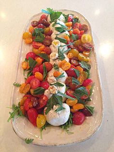 a white platter filled with lots of different types of food on top of a table