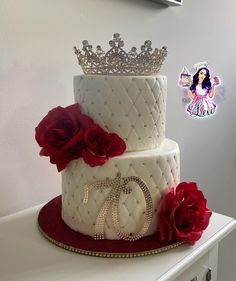 a white cake with red flowers and a tiara on top