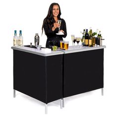 a woman standing behind a bar with lots of bottles and glasses on top of it