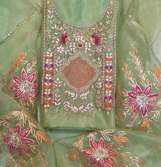 an embroidered green dress with pink and orange flowers on the bottom, along with matching sleeves