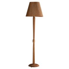 a wooden floor lamp with a beige shade on it's base and a white background