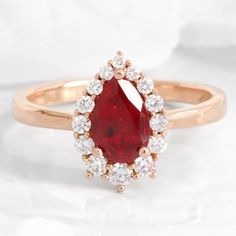 a close up of a ring with a red stone in the center and white diamonds around it