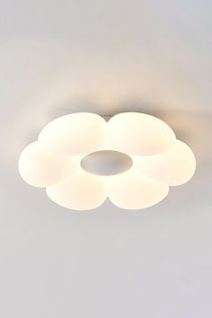 a white ceiling light with four lights on it's sides and three circular shades