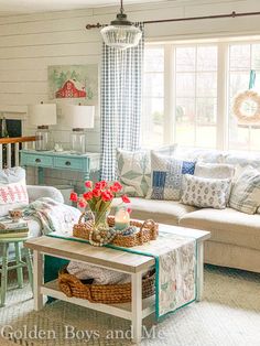 a living room filled with lots of furniture and flowers on top of a coffee table