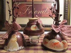 three brown vases sitting on top of a checkered table cloth covered tablecloth