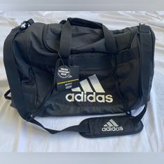 the adidas duffel bag is black and white