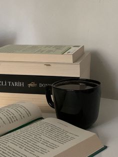 two books and a cup on a table