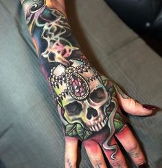 a woman's hand with a tattoo on it and a skull in the middle