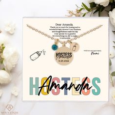 a card with the words hostess and two charms on it next to some white flowers