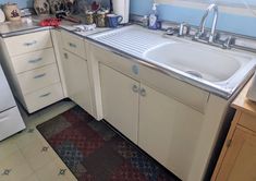 a kitchen with a sink and dishwasher next to a counter top on a tiled floor