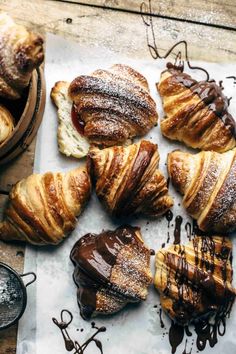 pastries are arranged on a table with chocolate drizzled around them